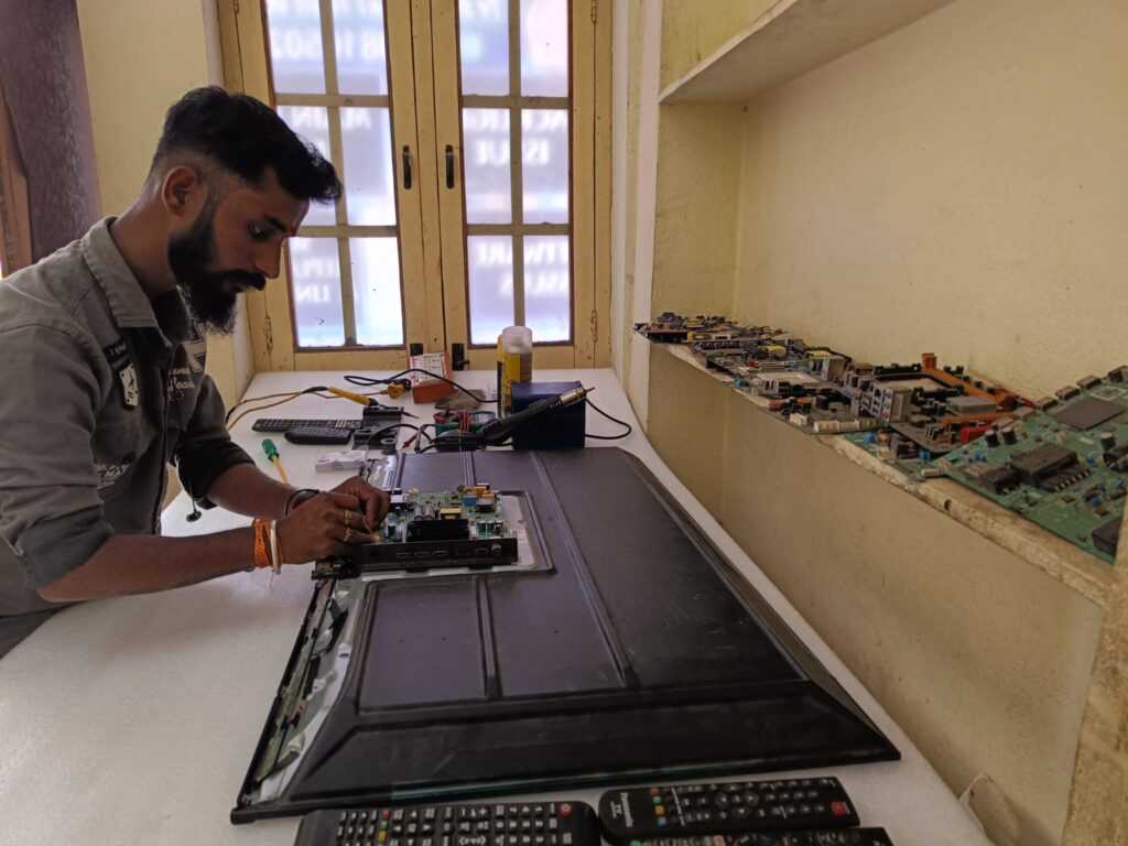 Unique TV Services technician inspecting broken TV screen
